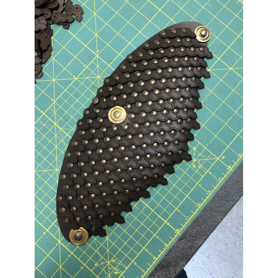 Pièce d’armure fabriquée avec des écailles en cuir courbées rivetées