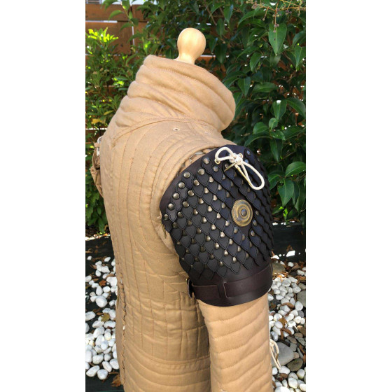 Armure d’épaule en écailles de cuir portée sur une tenue de GN